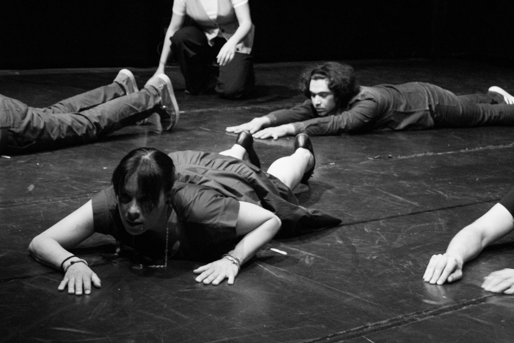 IDRAfactory on stage 7 giugno: membri del corso di Teatro del secondo e terzo anno che strisciano sul palco